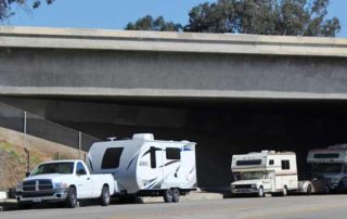 RVs parked under bridge